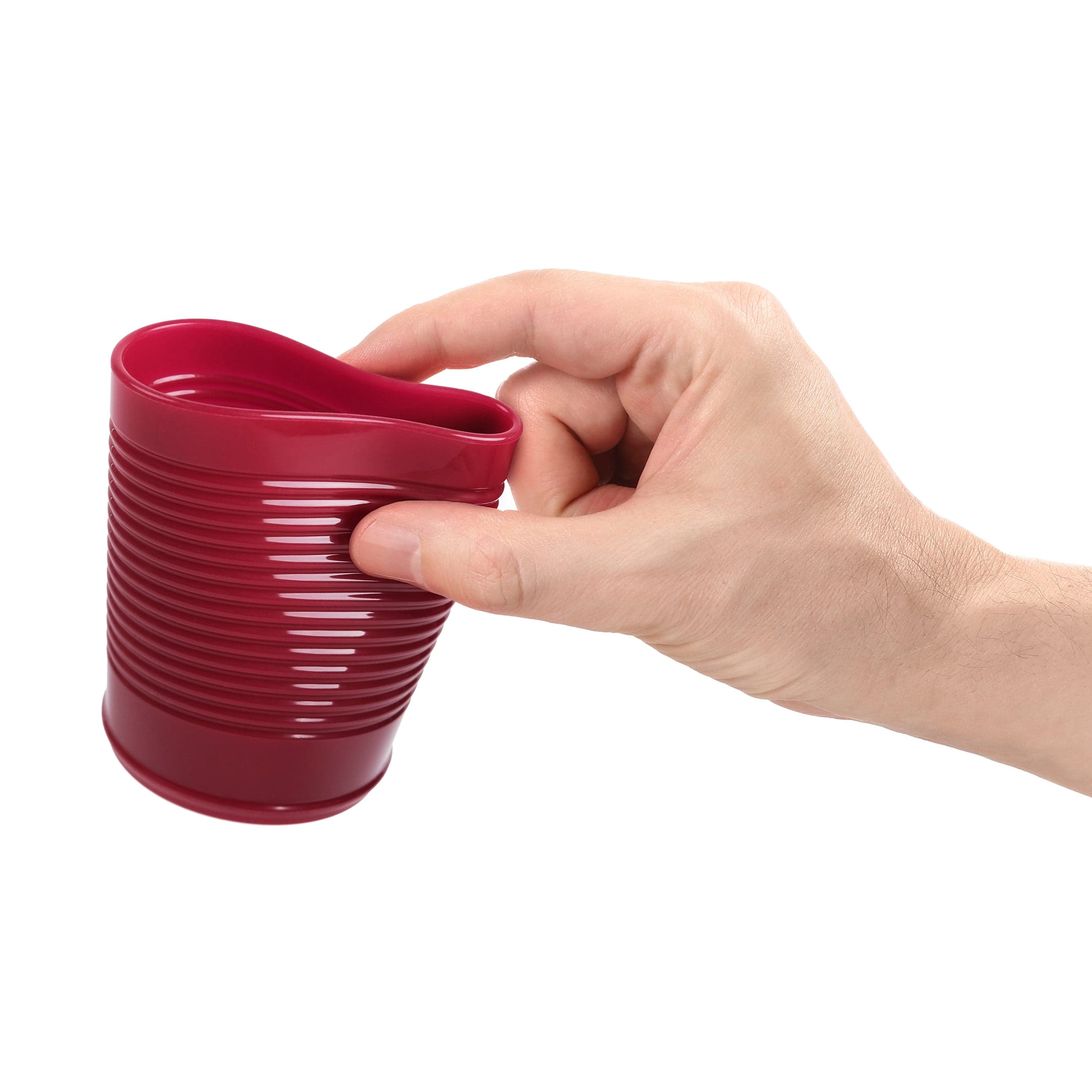 Hand holding a squishy flexible red, ribbed cranberry sauce cup against a white background