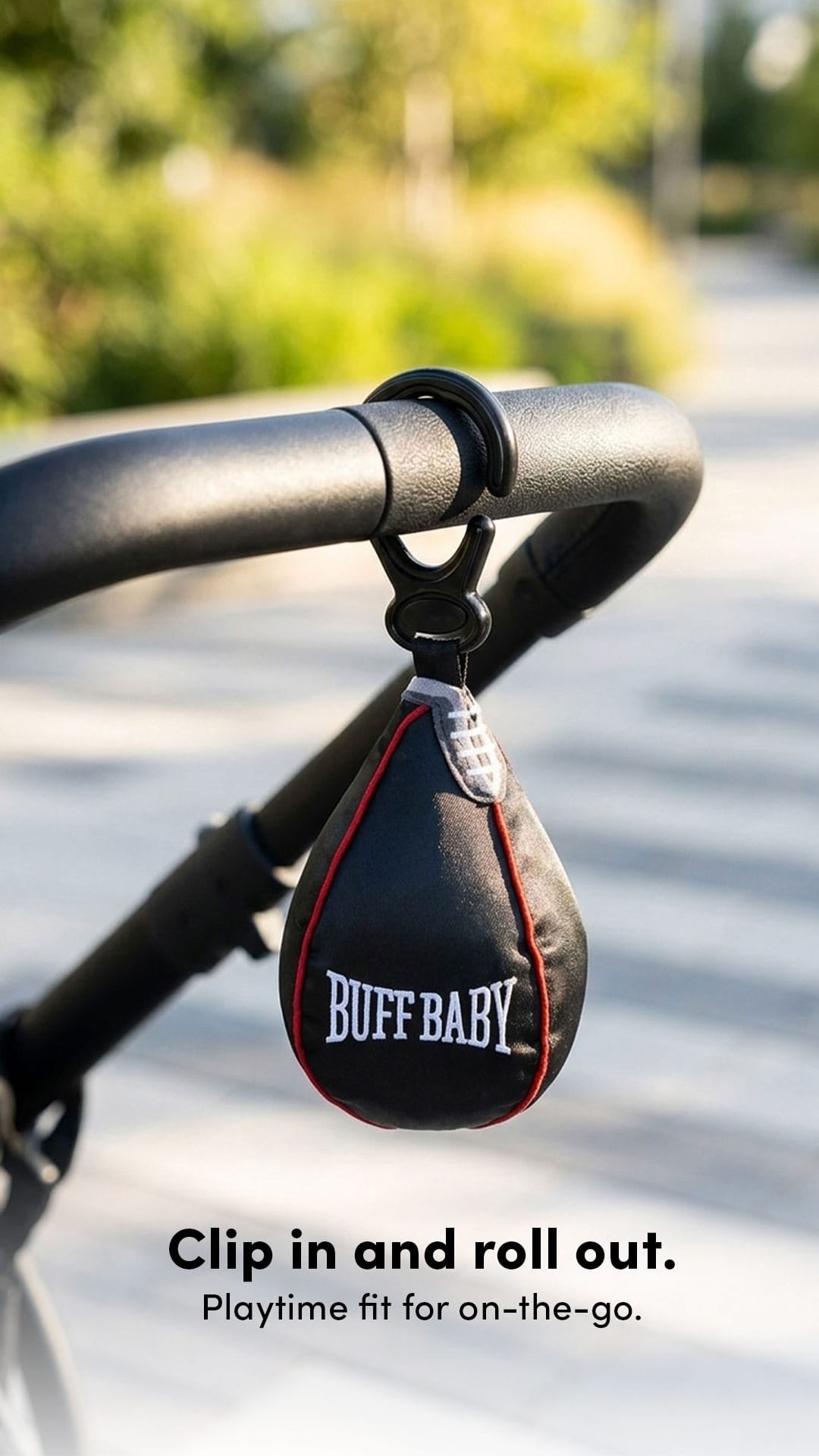 Buff Baby toy attached to a stroller with text 'Clip in and roll out. Playtime fit for on-the-go.'