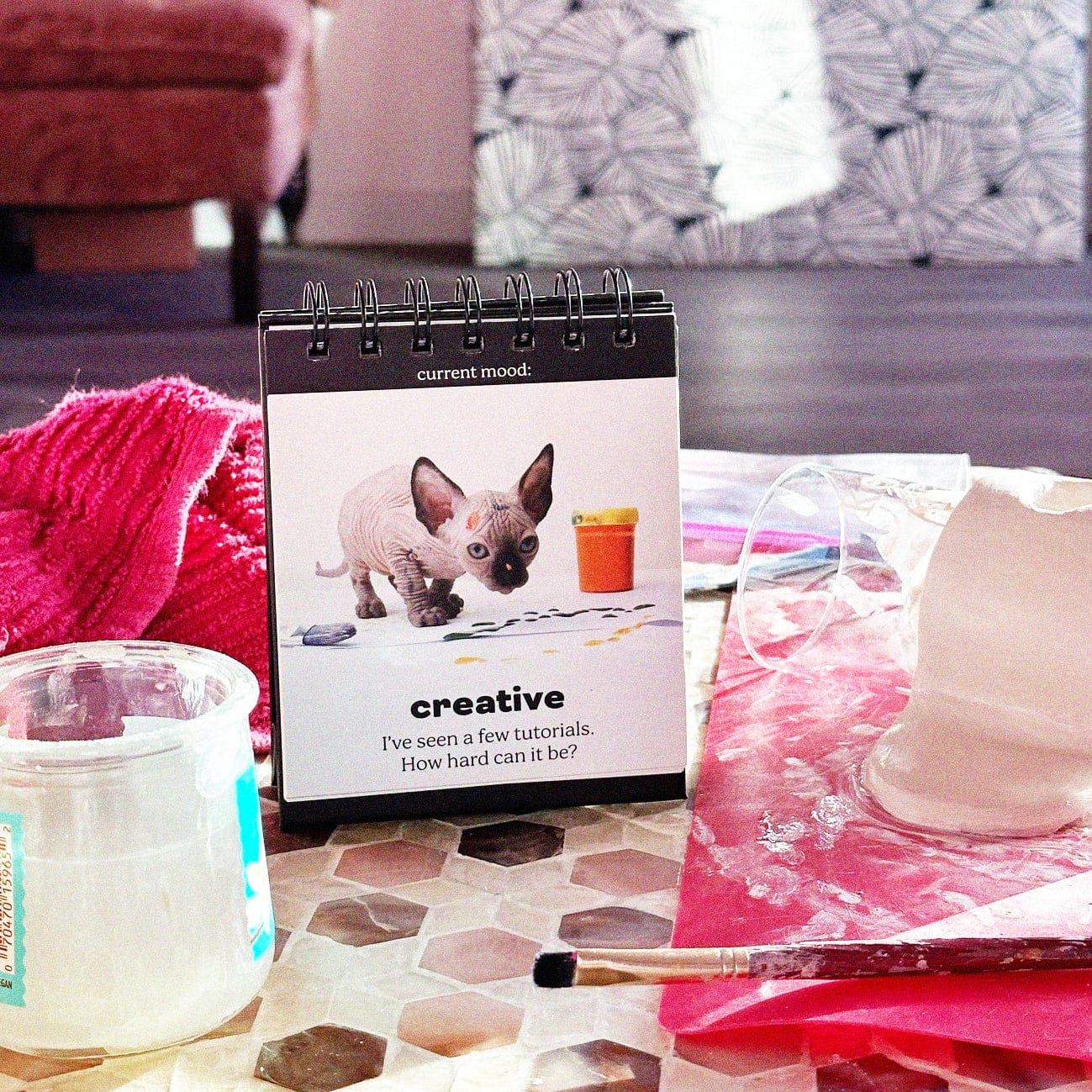 Fred's Daily Cattitudes flipchart  on the page for "Creative", shown in a messy artistic environment.