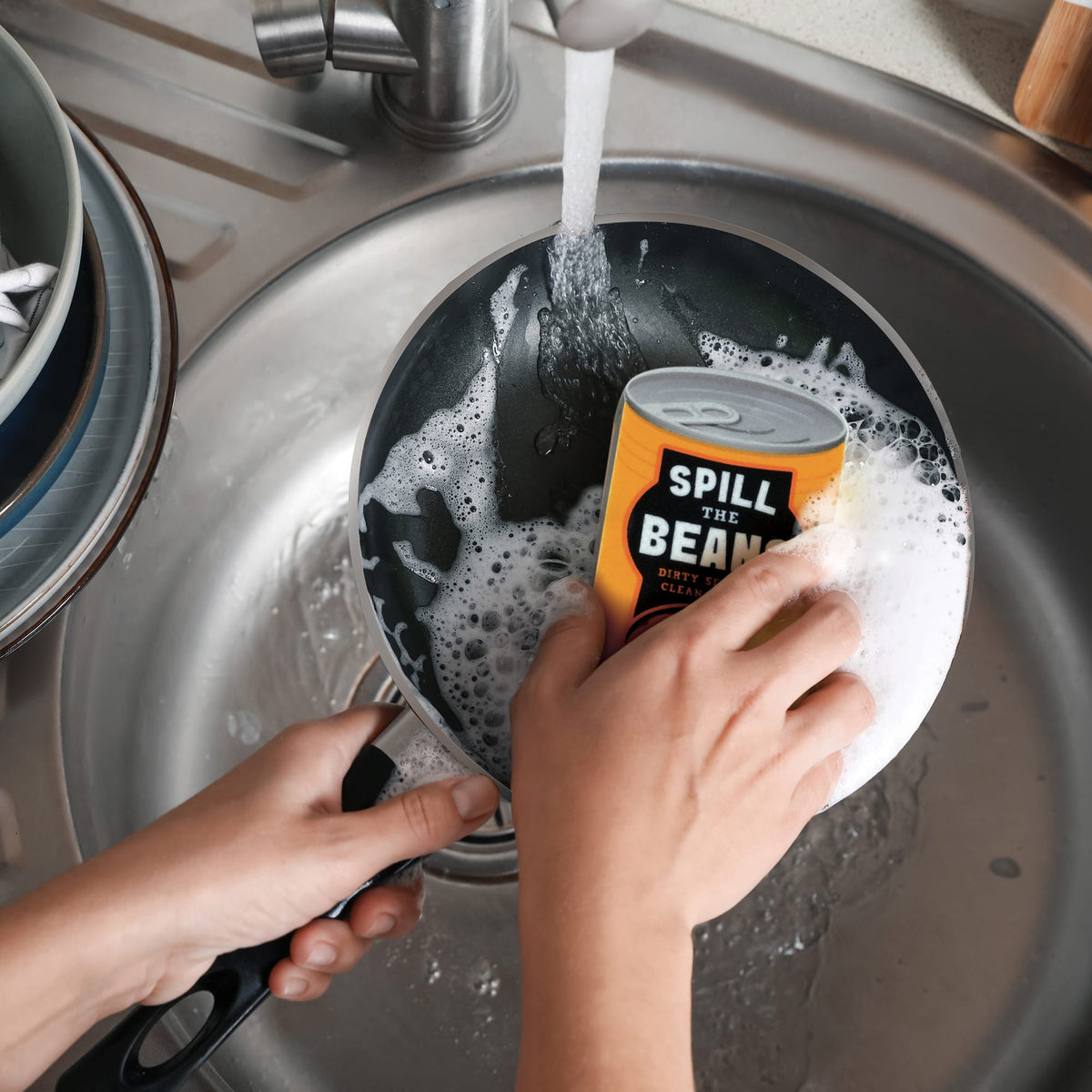 Hands washing a Spill the Beans can in a sink under running water