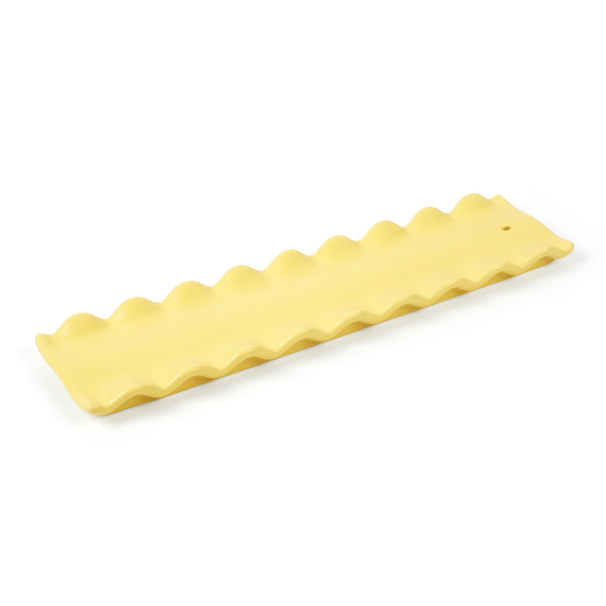 CARB APPEAL yellow wavy edge silicone mat with a wooden stick across it