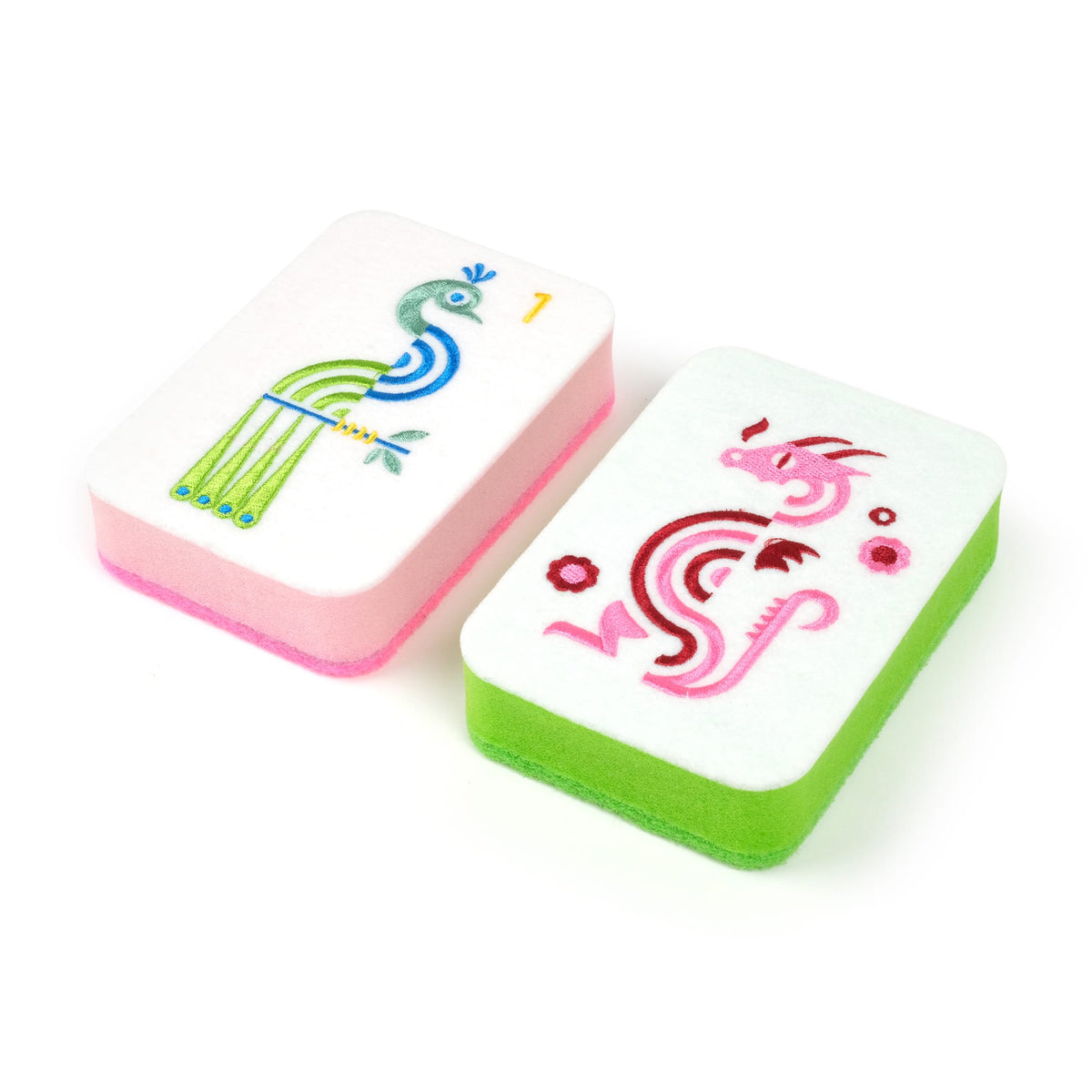 White kitchen sponge with pink edge and a colorful peacock illustration
