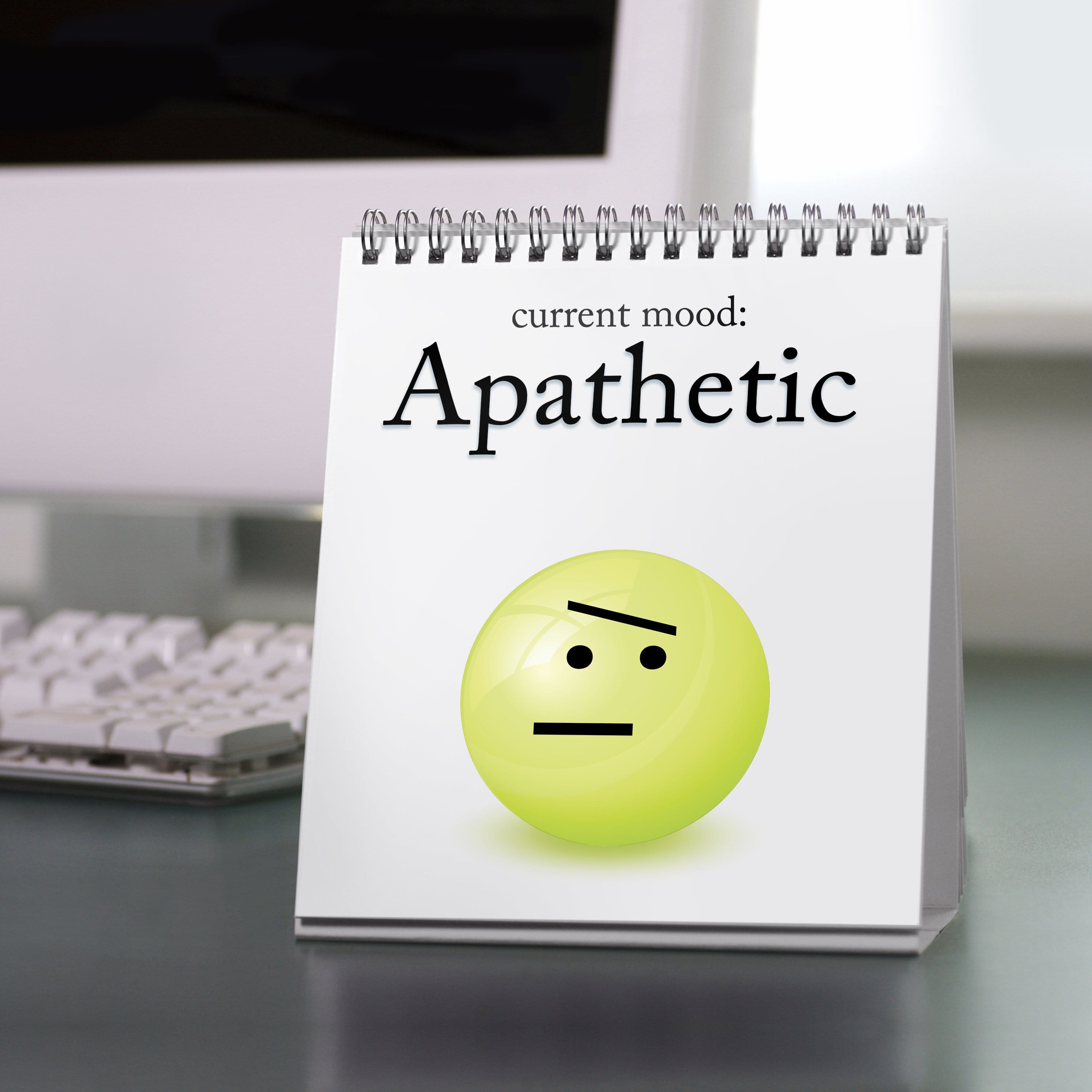 The Daily Mood flip book sitting on an office desk beside a computer, a humorous gift for coworkers, teachers, or students.