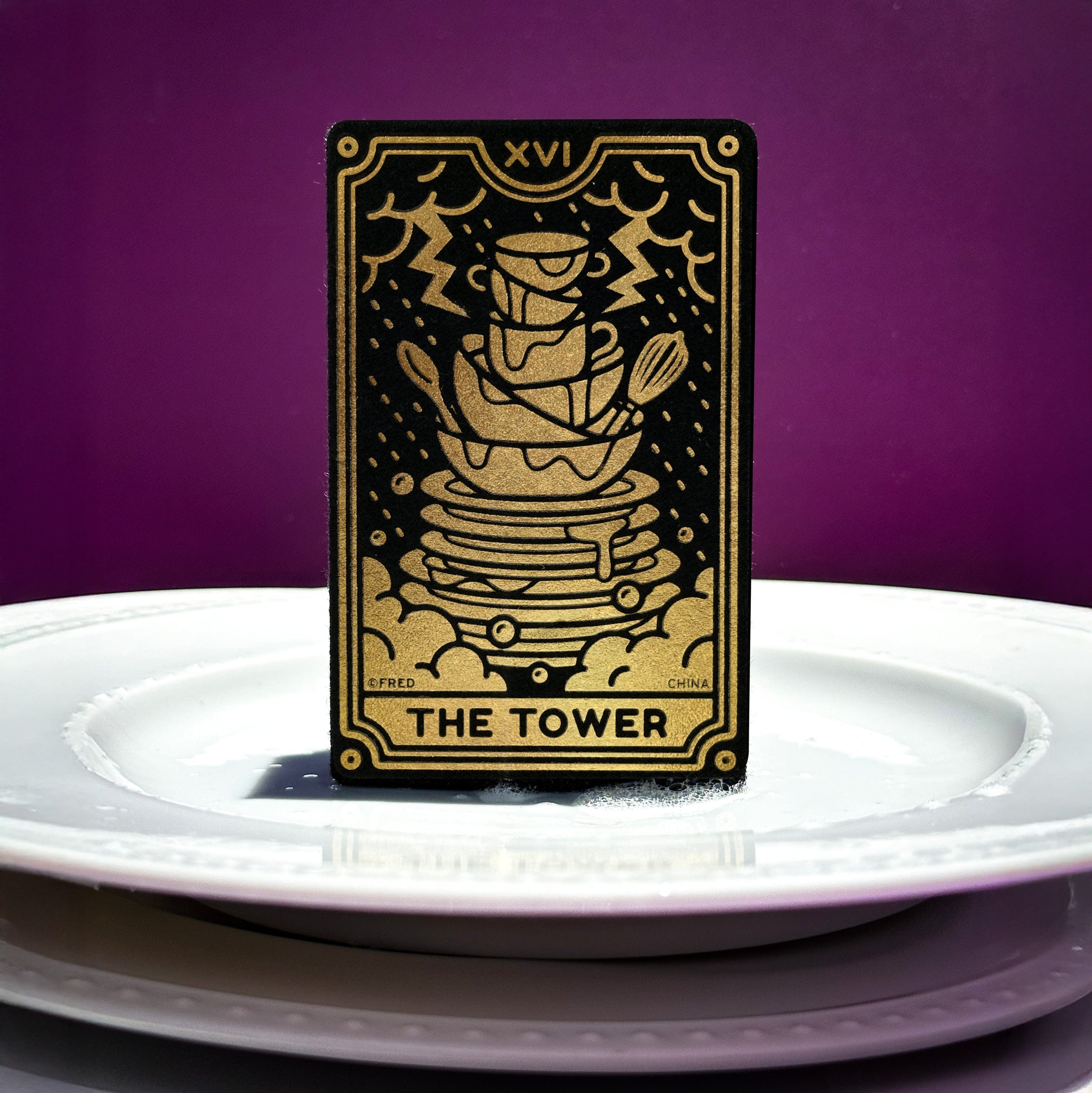 Tarot card sponge titled 'The Tower' on a white plate with a purple background