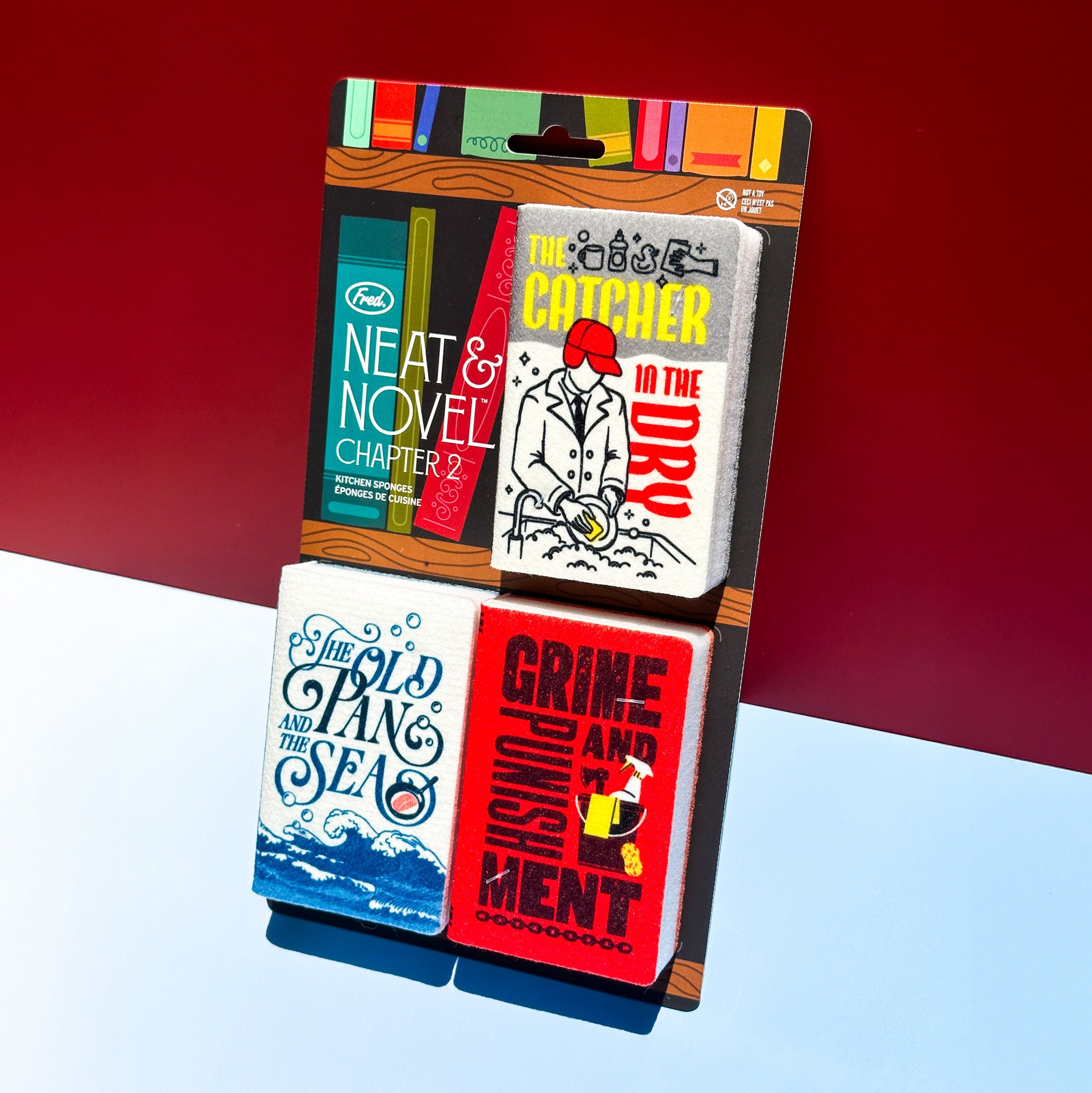 Set of three book sponges with colorful covers on a red and blue gradient background