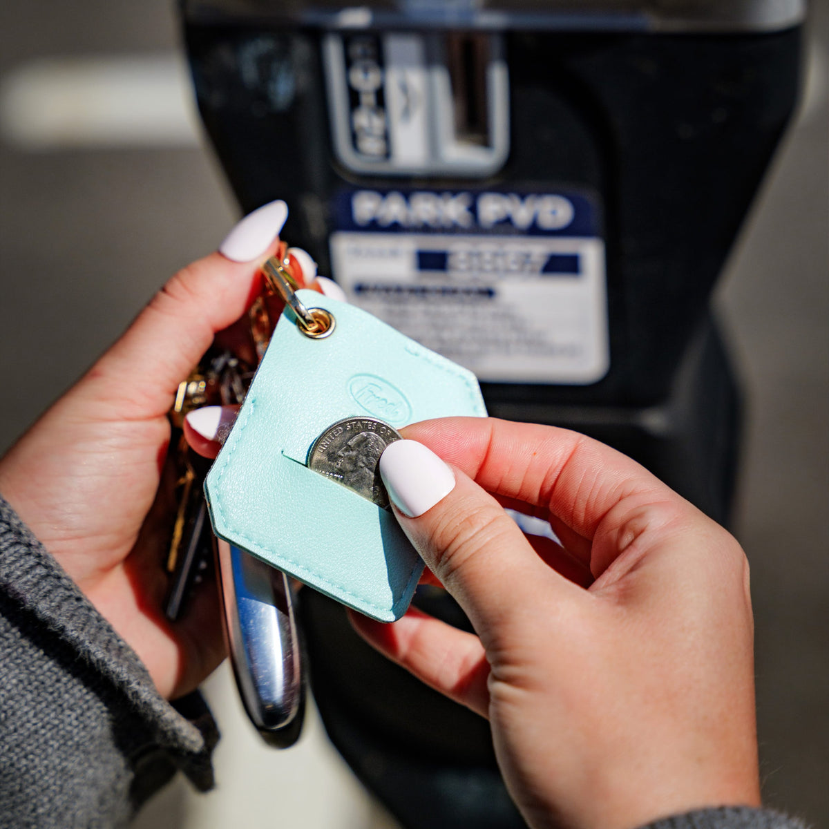 Hands inserting a coin into the back pocket of the turquoise Mahjong bag charm. A top-rated practical stocking stuffer and fun holiday gift idea $10 and under.