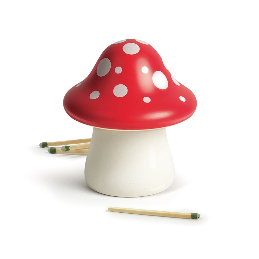 A ceramic mushroom with a red & white polka dot top. Surrounded by unlit matches