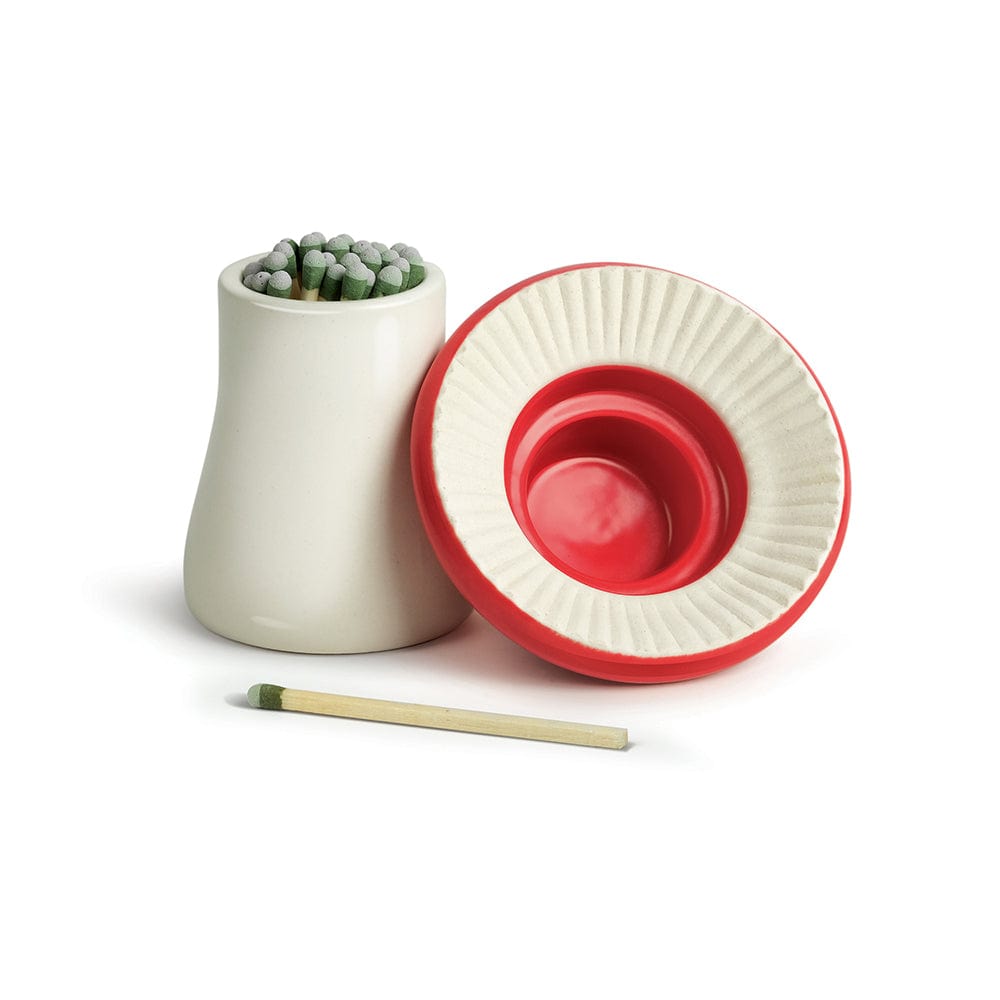 A ceramic vessel holding matches. The top of the vessel looks like a mushroom and is placed upside down.